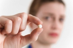 Woman holding pill
