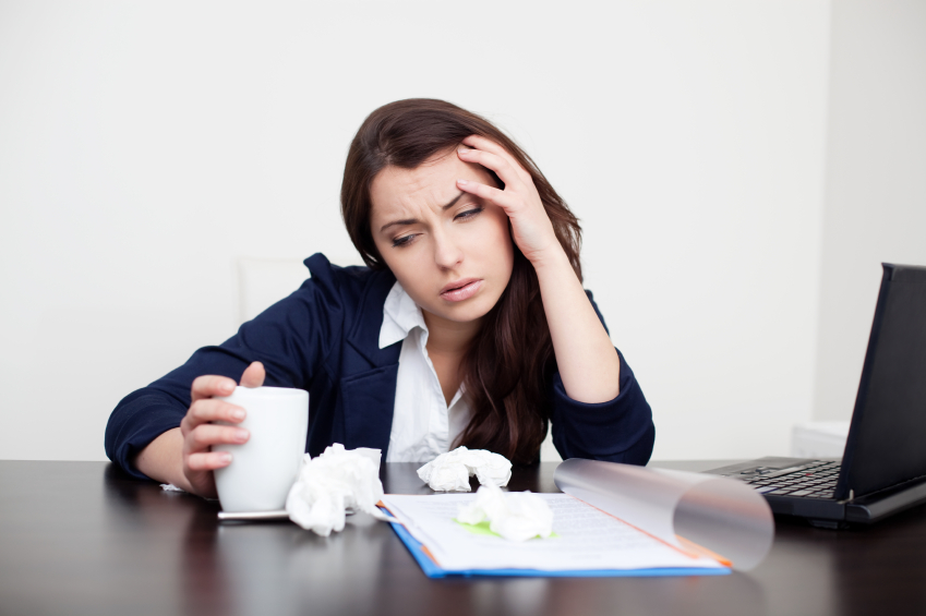 Sick woman at work drinking coffee